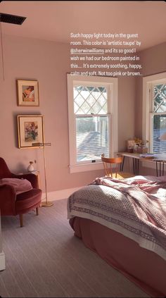 a bedroom with pink walls and pictures on the wall above the bed, in front of a window