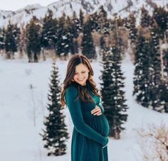 a pregnant woman is standing in the snow