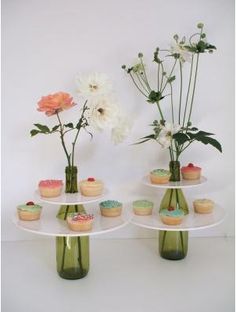 three vases with flowers and cupcakes on them