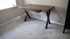 a wooden desk sitting in the corner of a room