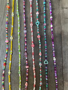 multicolored beaded necklaces hanging on a wooden surface