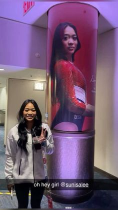 a woman standing in front of a giant advertisement for the u s cellular phone company