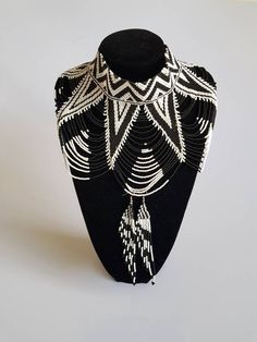 This shoulder necklace is made using black and white fine beads. Perfect for weddings or African themed events. **Buy multiple items and pay shipping for 1 item only.The rest ships free. More neckleces here; https://www.etsy.com/shop/TribalTess?ref=seller-platform-mcnav&section_id=21306083 Back to my shop; https://www.etsy.com/shop/TribalTess?ref=seller-platform-mcnav Unique White Choker Necklace, White Beaded Backdrop Necklace For Parties, Black Bohemian Beaded Necklaces For Weddings, Bohemian White Jewelry With Black Beads, White Beaded Choker For Wedding, Bohemian White Pearl Necklace For Party, Black Beaded Wedding Jewelry, White Bohemian Pearl Necklace For Party, White Beaded Chain Choker For Party