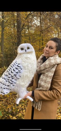 a woman holding an owl in her hands