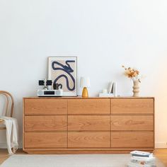 a wooden dresser sitting next to a white wall