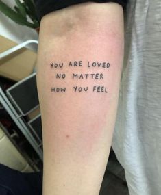 a person with a tattoo saying you are loved no matter how you feel on their arm