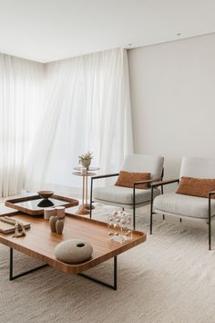 a living room with two chairs and a coffee table in front of a large window