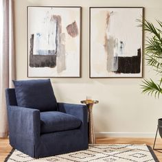 a living room with two paintings on the wall and a blue chair next to it