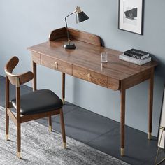 a wooden desk with a chair next to it and a framed photograph on the wall