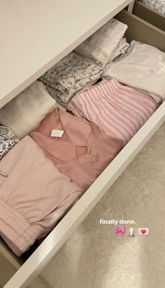 an open drawer with clothes in it