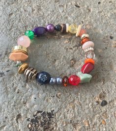 a bracelet with many different colored beads and charms on it's end is laying on the ground