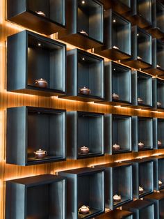 the shelves are lined with pots and pans on them, all lit up by dim lighting