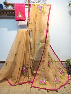 Exquisite embroidery work in floral design has been neatly and densely done on a sandalwood color Resham check saree. Here we have used multicolor Resham thread and shaded embroidery technic (Minakari work).  Two different sizes of floral designs are spread all over the saree. This saree is framed with a rani pink color border accessorized with handmade tassels. This saree comes with a hand embroidered contrast blouse piece. This saree is summer-friendly and very comfortable to wear. Details: *Blouse: With Hand Embroidered Blouse Piece *Fabric: Handloom Resham check saree *Work: Machine Embroidery work  this work is neither Computerized Machine Embroidery work nor machine Aari Embroidery with woolen thread. * Its completely Manual Machine Embroidery Work with silk threads..] *Saree length: Beige Bollywood Saree With Resham Embroidery, Embroidered Beige Saree In Traditional Drape, Traditional Embroidered Beige Saree, Festive Embroidered Beige Saree, Festive Beige Embroidered Saree, Embroidered Beige Saree For Festivals, Bollywood Style Embroidered Beige Saree, Semi-stitched Chanderi Saree In Beige, Semi-stitched Beige Chanderi Saree