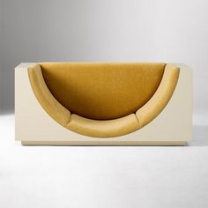 a yellow and white couch sitting on top of a white floor next to a wall