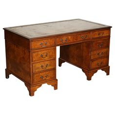 an old wooden desk with two drawers on one side and a marble top on the other