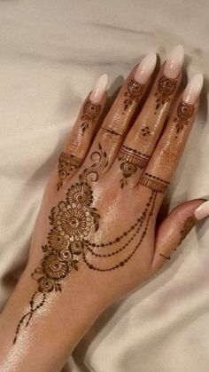 a woman's hand with henna tattoos on it