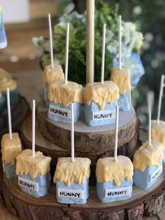 there are many desserts on the table with sticks sticking out of them and some flowers in the background