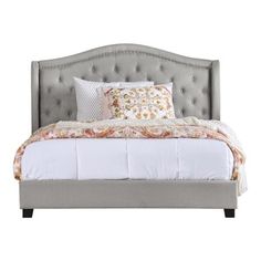 an upholstered bed with white sheets and pillows on the headboard, against a white background