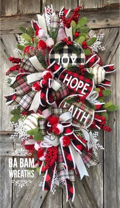 a christmas wreath with the words joy hope and snowflakes hanging on a door