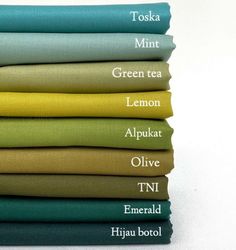 six different colors of teal, green, lemon, and olive linens stacked on top of each other