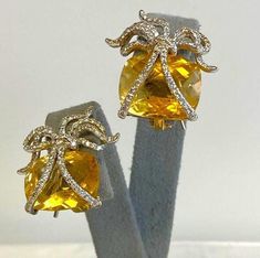 Pair 18K Yellow Gold Citrine & Diamond Earrings DescriptionPair 18K Yellow Gold Earrings; Convertible Posts; Omega Clip; 178 Round Brilliant Cut Diamonds 0.89 Carat Total Weight, I-1, H; Bow Motif; 2 Checkerboard Cushion Cut Citrine 16.84 Carat Total Weight; 14.0 Grams Payment All payments must be made through PayPal, NO EXCEPTIONS. We cannot accept payment plans. We do not offer Layaway. Shipping We ship via USPS Registered Mail, Return Receipt in order to provide tracking and insured delivery, which usually takes 5-7 days ($25) **OVERNIGHT SHIPPING available upon request ($40); please request overnight shipping upon your winning bid!! Expedited shipping fee will be added to your total AND expedited shipping service will be arranged for you.  We ship within one business day (holidays and Luxury Yellow Gold Citrine Earrings, Yellow Earrings With 17 Jewels For Formal Occasions, Formal Yellow Earrings With 17 Jewels, Yellow Citrine Earrings For Formal Occasions, Formal Yellow Citrine Earrings, Formal Yellow Clip-on Earrings, Luxury Yellow Gemstone Earrings, Yellow Citrine Earrings For Wedding, Convertible Earrings