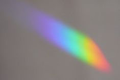 the rainbow is shining brightly on the wall in the room with the light coming through it