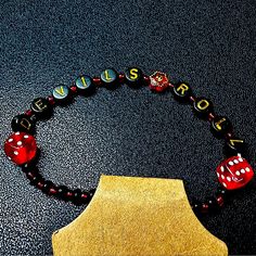 a red and black beaded bracelet with dices on it