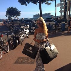 a woman walking down the street carrying shopping bags