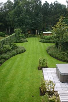 an aerial view of a large green lawn and garden area with a hot tub in the middle