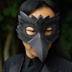 a woman wearing a black mask with an owl's head cut out on it