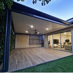 an outdoor living area with wooden flooring and sliding glass doors that open up to the backyard