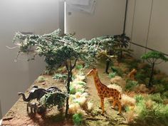 a fake giraffe and an ostrich are on display in a museum