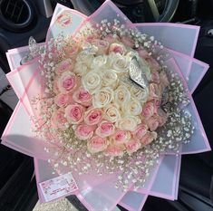 a bouquet of pink and white roses in a car