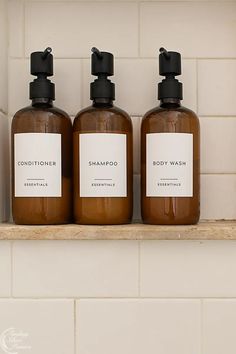 three bottles of body wash sitting on a shelf