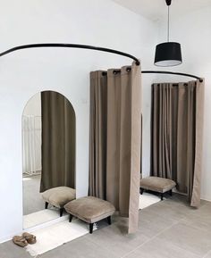 a room with three mirrors and two stools