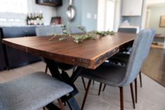 a wooden table with grey chairs around it