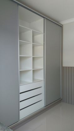 an empty room with white shelves and gray walls