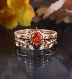 a close up of a ring on a table with flowers in the background