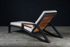 a chair made out of wood and white fabric with a black frame on the back