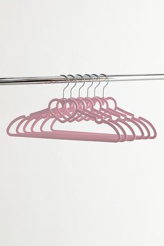 several pink hangers are hanging on a white wall