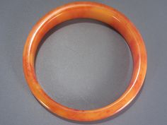 This beautiful vintage Bakelite bangle bracelet is a marmalade orange color and tapers from 1/2 inch to 1/4 inch wide. The bangle has an inner circumference of 7 3/4 inches with a 2 1/2 inch wide inner opening and measures 3 inches wide outer to outer side. In excellent vintage condition. As with all my Bakelite, guaranteed to be authentic and vintage, tested with several reliable methods including simi chrome polish. Bakelite Bangles, Vintage Bakelite, Feb 2, Marmalade, Bangle Bracelet, Orange Color, Bangle Bracelets, 4 Inch, Bangles