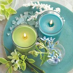 two candles are sitting on a plate with flowers