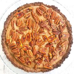 a pie with pecans on top sitting on a table