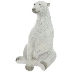 a white polar bear statue sitting on its hind legs and looking at the camera with an alert look