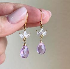 Lavender Quartz Earrings, February Birthstone, Petite Soft Purple Teardrop Flower Earrings in Gold or Silver, Lilac floral drop jewelry gift These simple but elegant earrings feature flawless faceted Lavender Quartz teardrop shape stone wire wrapped in gold filled or sterling silver. The soft pastel purple teardrops are suspended from a floral three petal flower element adorned in white topaz in the finish of your choice. The lilac hue earrings close with lever back ear wires.  These earrings are adorably petite, very feminine and have super simple elegant lines. These make an ideal holiday gift or a birthday gift for a women born in February, as this is one of the birthstones of the month of February. About These Earrings: - Gemstone: Lavender Quartz - Birthstone: February - Lavender Quar Drop Jewelry, Lavender Quartz, Silver Gift Wrap, Petal Flower, Earrings Gemstone, Soft Purple, Earrings In Gold, February Birthstone, Pastel Purple