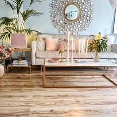 a living room filled with furniture and decor on top of a wooden floor next to a mirror