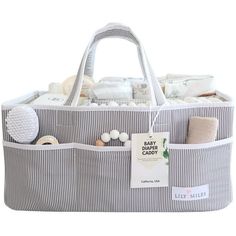 a large gray and white striped bag filled with baby items on top of a white background