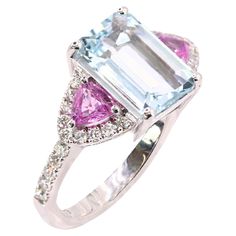 an aqua and pink tourmaline ring with diamonds on the sides, set in white gold