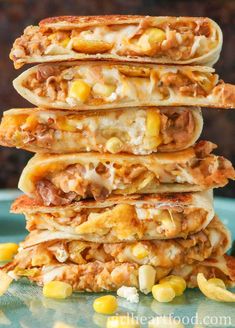 three quesadillas stacked on top of each other with corn in the background