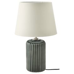 a table lamp with a white shade on it and a black cord plugged into the base